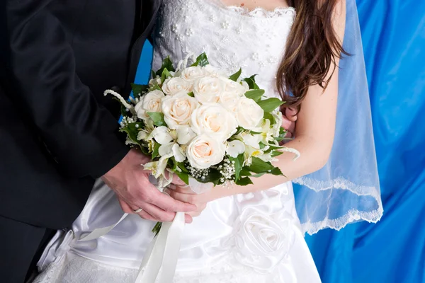 Un hermoso ramo de rosas en las manos de la novia y el novio — Foto de Stock