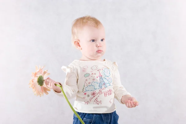 Meisje met een roze bloem in handen — Stockfoto