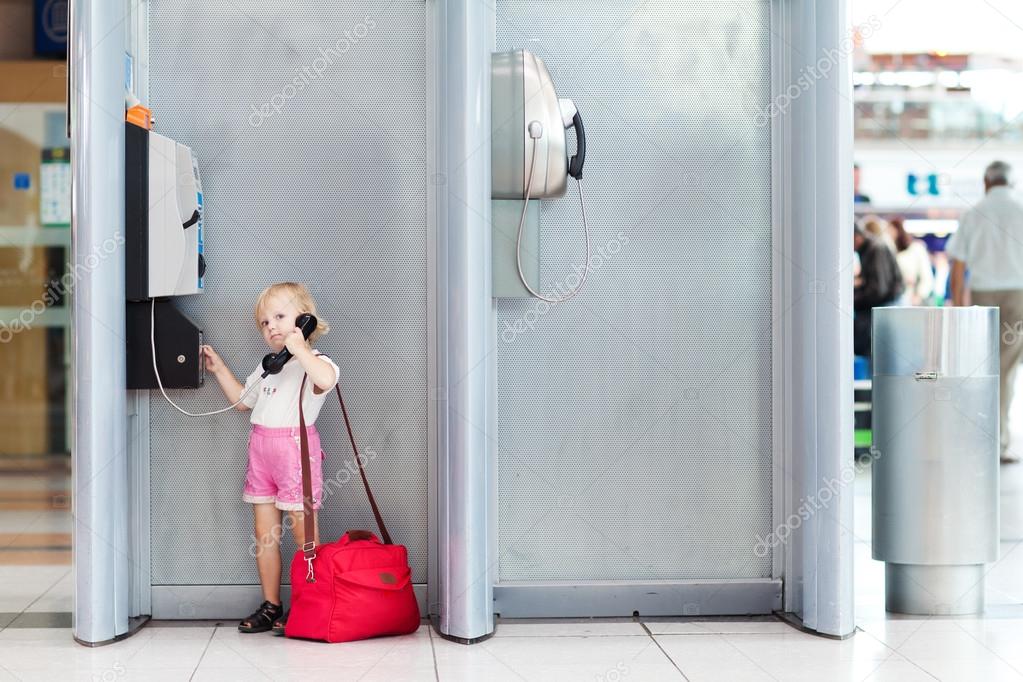 child talking the phone in the airport