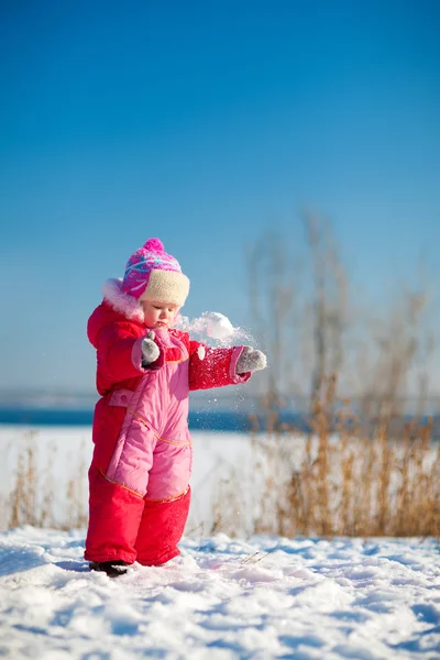 Barn kastar snö på vintern — Stockfoto