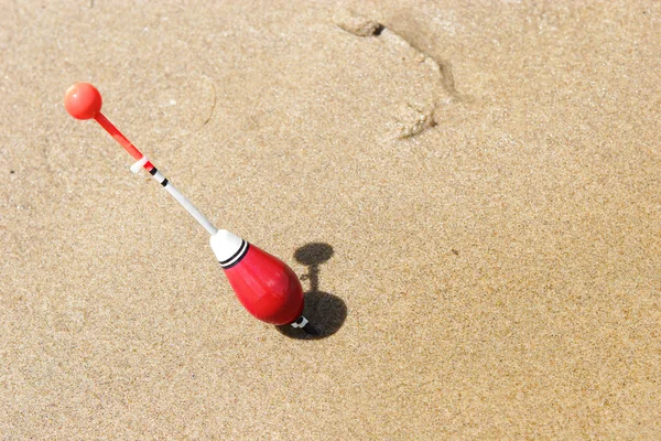Un galleggiante da pesca infilato nella sabbia — Foto Stock