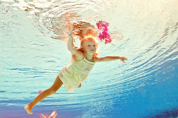 Plavání pod vodou dívka s květinou — Stock fotografie