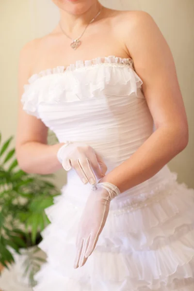 Bruid zet op een witte handschoen — Stockfoto