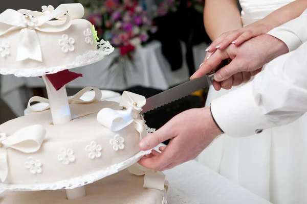 Schneiden eines Scheibchens einer Hochzeitstorte — Stockfoto