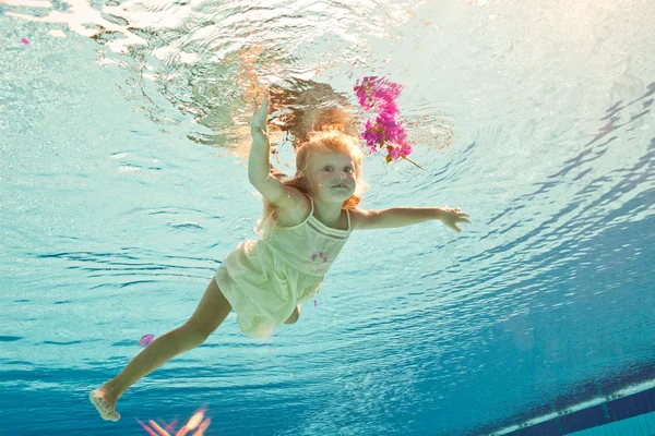 Simma under vattnet flickan med blomma — Stockfoto