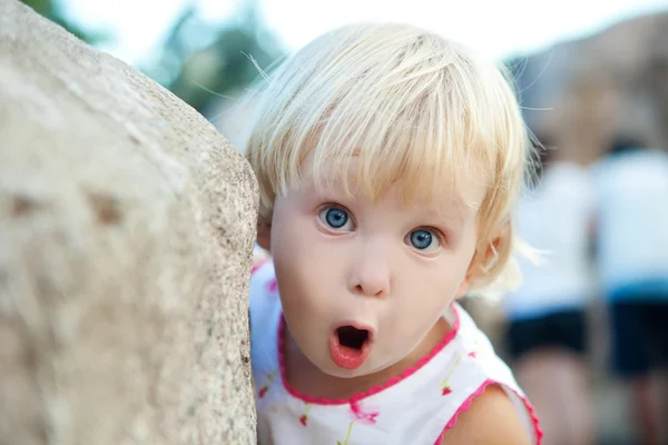 Surprised girl by the stone — Stock Photo, Image