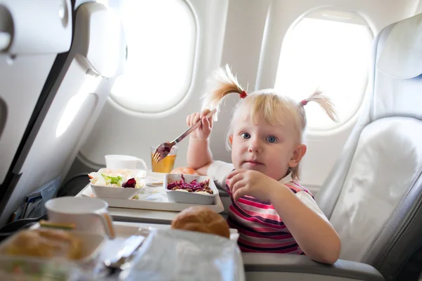 Девушка ест в самолете — стоковое фото