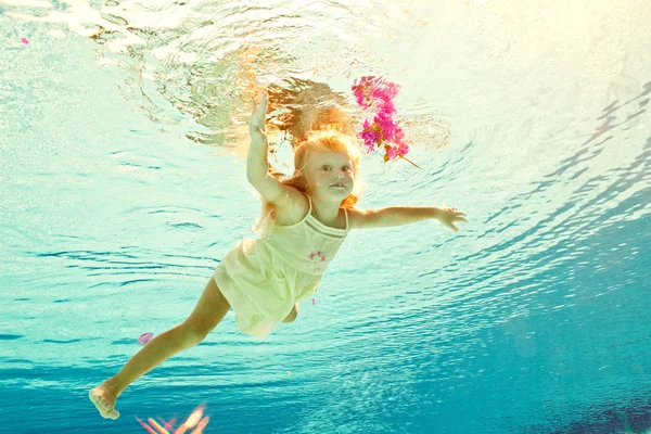 Nadando bajo el agua chica con flor — Foto de Stock