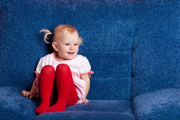 Šťastné malá holka na gauči — Stock fotografie