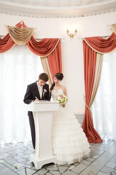 Bride and groom signing a wedding document — Stock Photo, Image