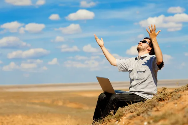 Man met laptop bidden tot de god — Stockfoto