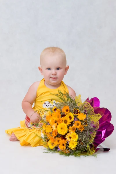 Uma menina pequena com um grande buquê de flores — Fotografia de Stock