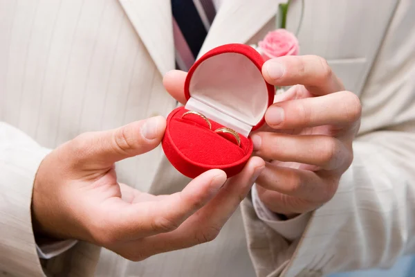 Caja con anillos de oro en las manos — Foto de Stock