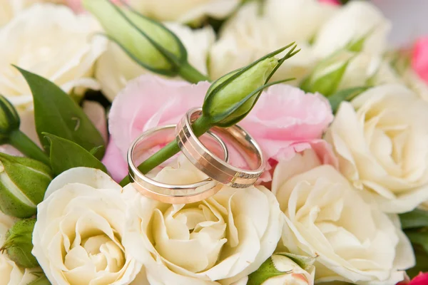 Gold rings and rose bouquet — Stock Photo, Image