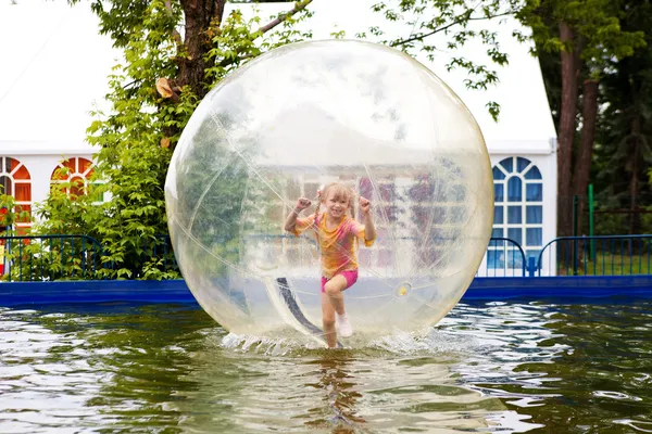 Kind in de bal in water — Stockfoto