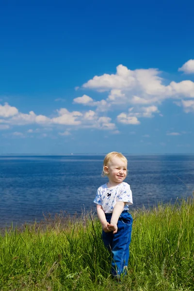 Lyckligt barn skruvar upp ögonen på solen — Stockfoto