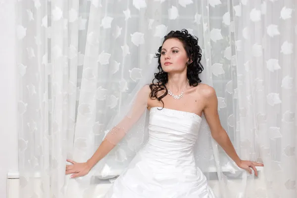 Eine schöne Braut am Fenster — Stockfoto