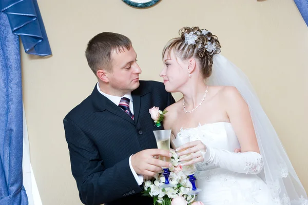 Bride and groom with glasses of champagne — Stock Photo, Image