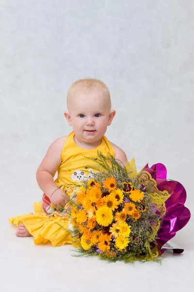 Una niña pequeña con un gran ramo de flores — Foto de Stock
