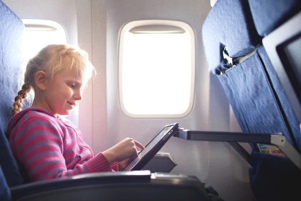Gilrl with ipad in the plane — Stock Photo, Image
