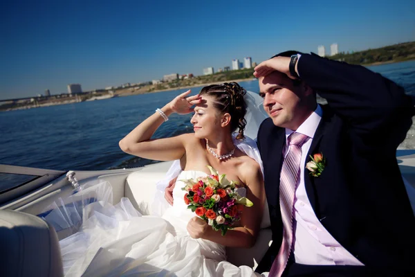 Bruden och brudgummen ser fram på båten — Stockfoto