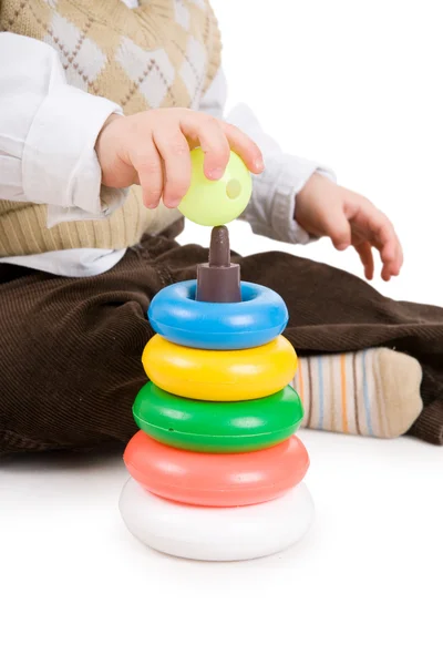 Hand of toddler boy puts on a sphere on pyramidion — Stock Photo, Image