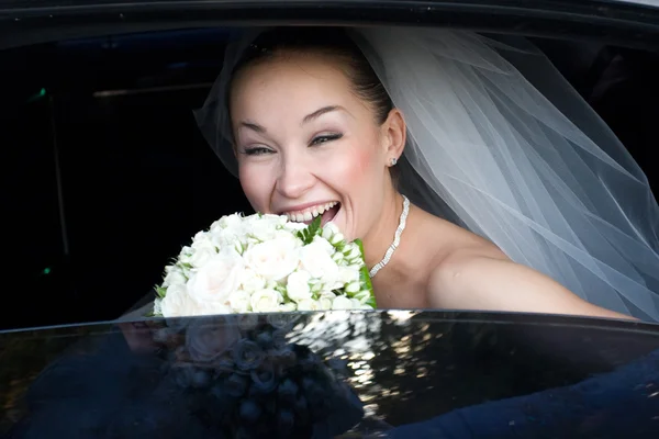 Braut lacht im Hochzeitsauto — Stockfoto