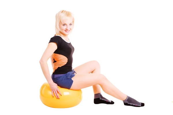 Een jong meisje, zittend op de grote bal voor fitness — Stockfoto