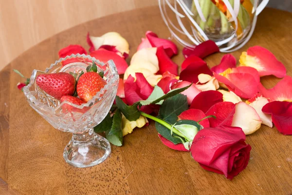 Tulip petals and strawberry on the table — Stock Photo, Image