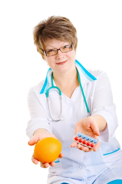 Médico con naranja y pastillas — Foto de Stock