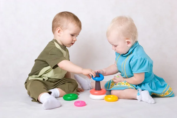 Liten flicka och pojke spelar i konstruktören — Stockfoto