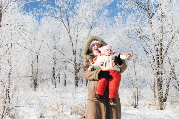 Una madre y un niño en un bosque de invierno mirando hacia arriba —  Fotos de Stock