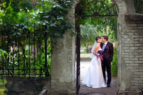 Bruid en bruidegom in de boog — Stockfoto