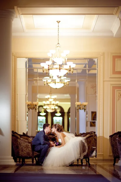 Bride and groom in golden hall — Stock Photo, Image