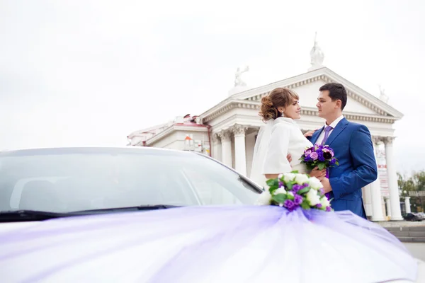 Novia y novio cerca del coche — Foto de Stock