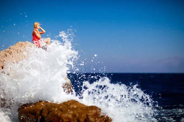 女孩在大海里的岩石上 — 图库照片