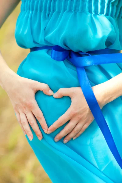 Hart op de zwangere buik — Stockfoto