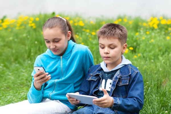 Zwei Kinder mit Gadgets Stockbild