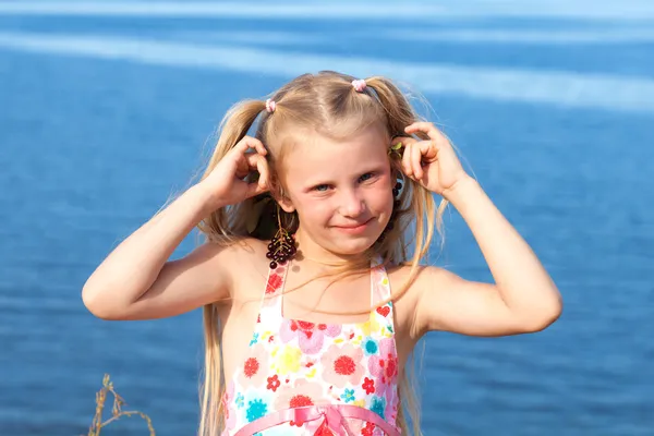 Girl with chokeberry on seashore — Stock Photo, Image