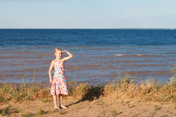 Девушка смотрит вперед на берегу моря — стоковое фото