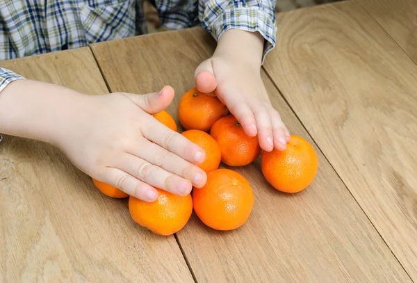 Ręce chłopca z pomarańczy — Zdjęcie stockowe