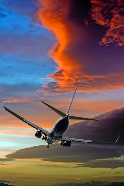 Passagerarplan mot stormiga solnedgång moln — Stockfoto