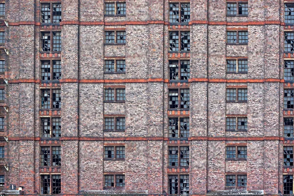 Gebroken windows in enorme braakliggende magazijn. — Stockfoto