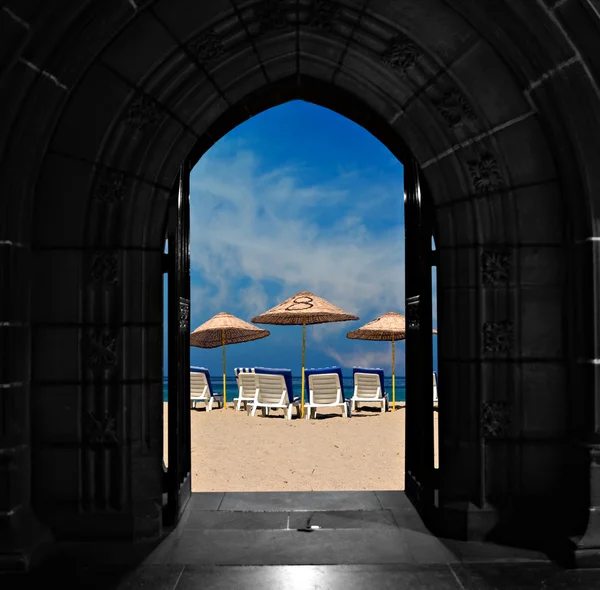 Looking through doors towards blue sky beach — Stock Photo, Image