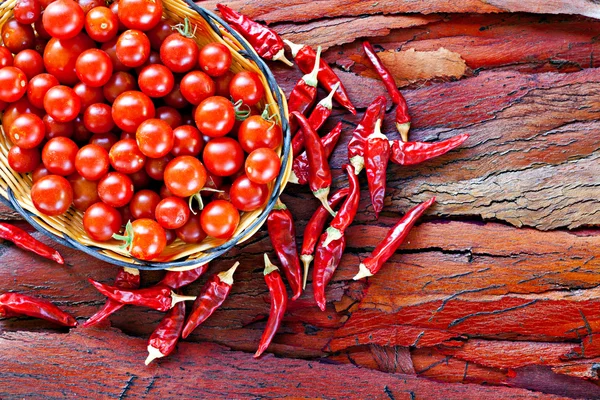 Érett cseresznye paradicsom és a rusztikus szárított piros chili — Stock Fotó