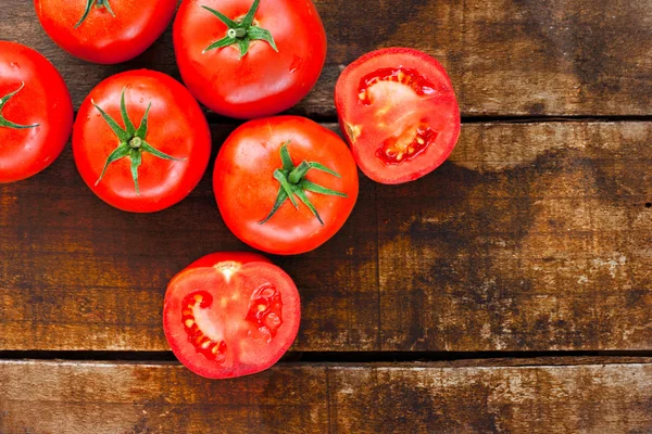 Dojrzałe czerwone pomidory na starym drewnianym stole — Zdjęcie stockowe
