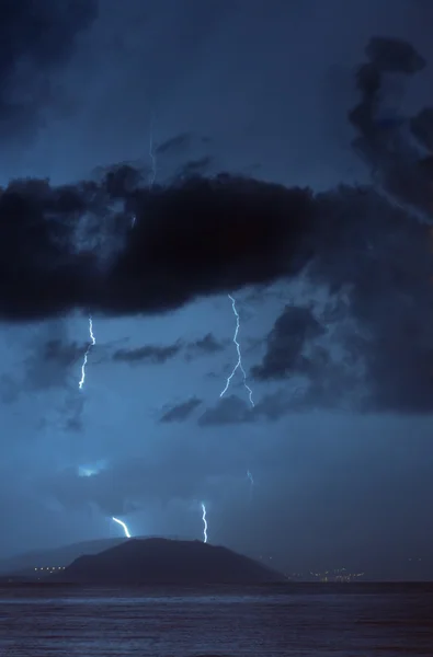 Lightning strike over small island at sea — Stock Photo, Image
