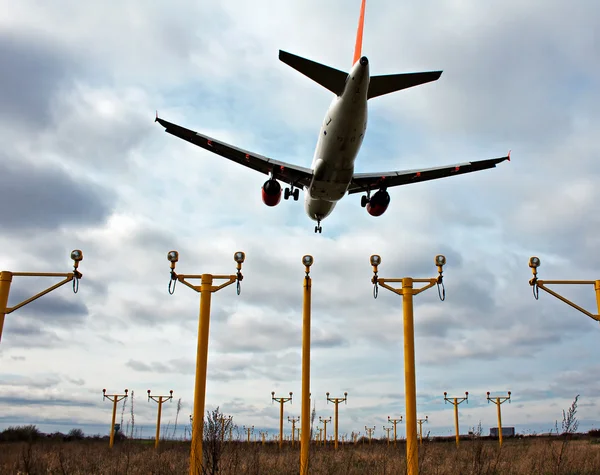 Avion de passagers en approche finale, avec feux d'atterrissage en vue — Photo