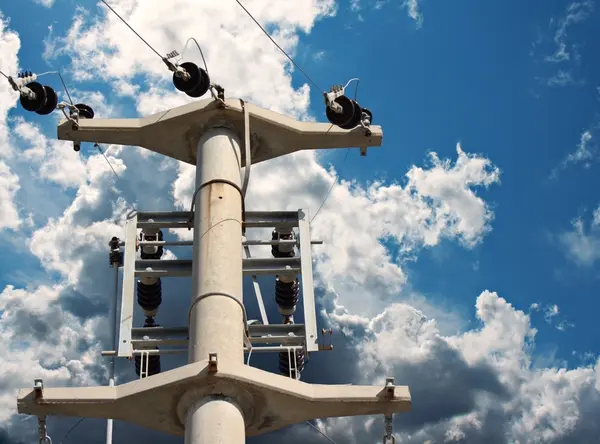 Pylône électrique contre un ciel bleu avec des nuages — Photo