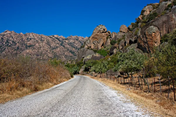 Roadway through unusual rock formations on mountain side — Stock Photo, Image